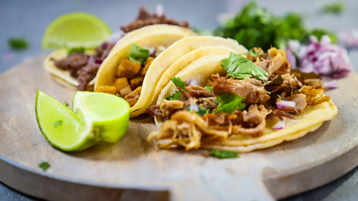 A plate of California-style street tacos on a wooden board
