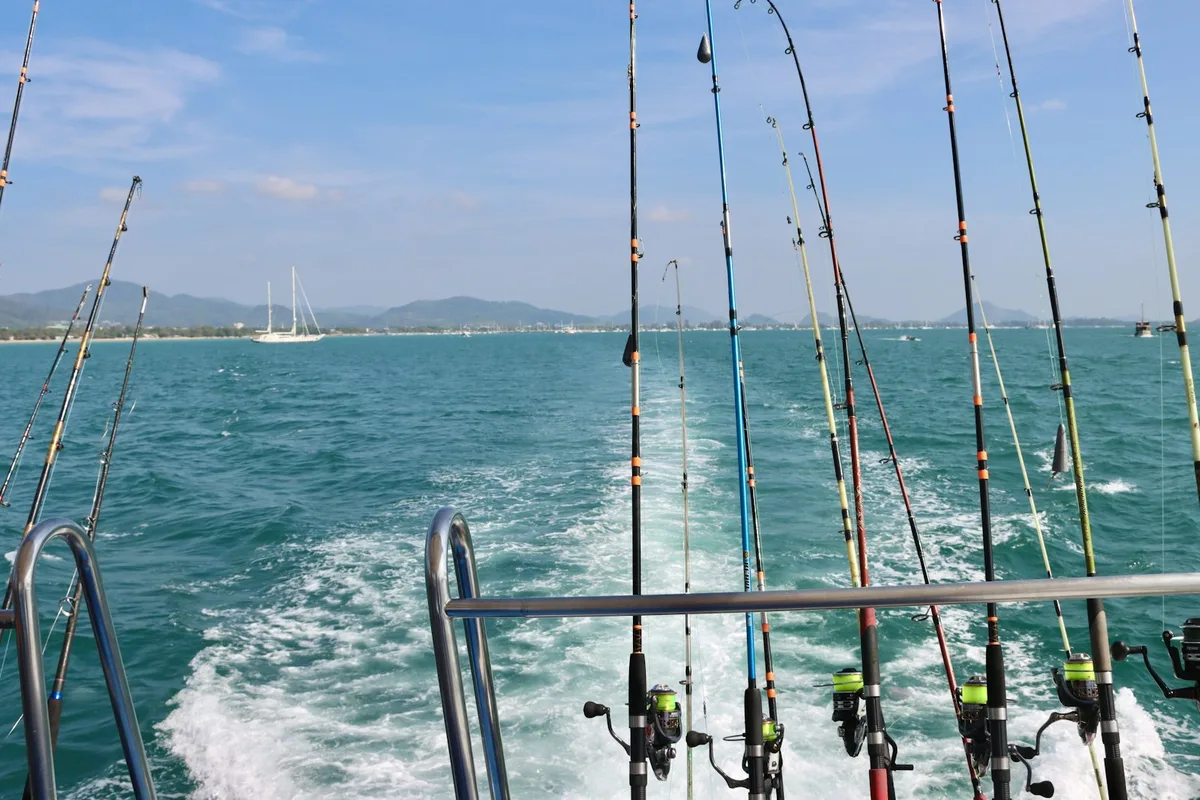 Fishing rods set up along the rail of a charter boat on the water