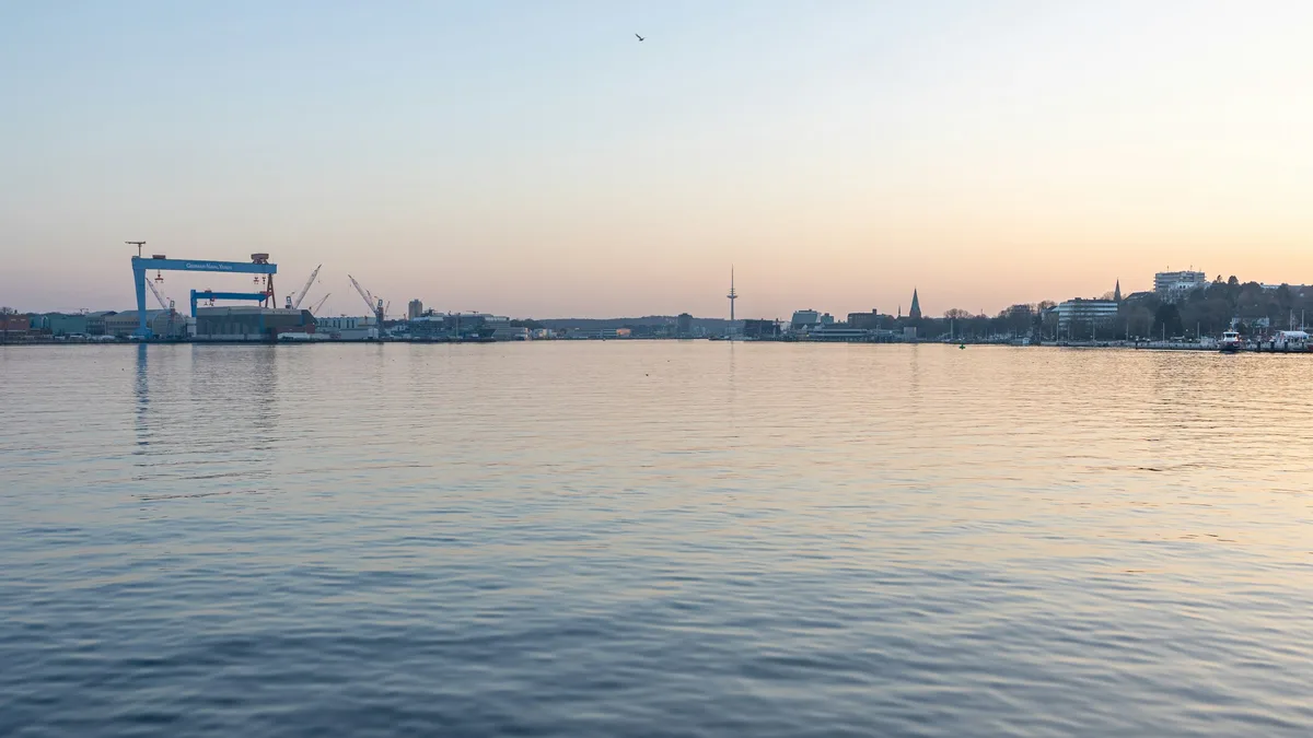 A city skyline with cranes and industrial port infrastructure