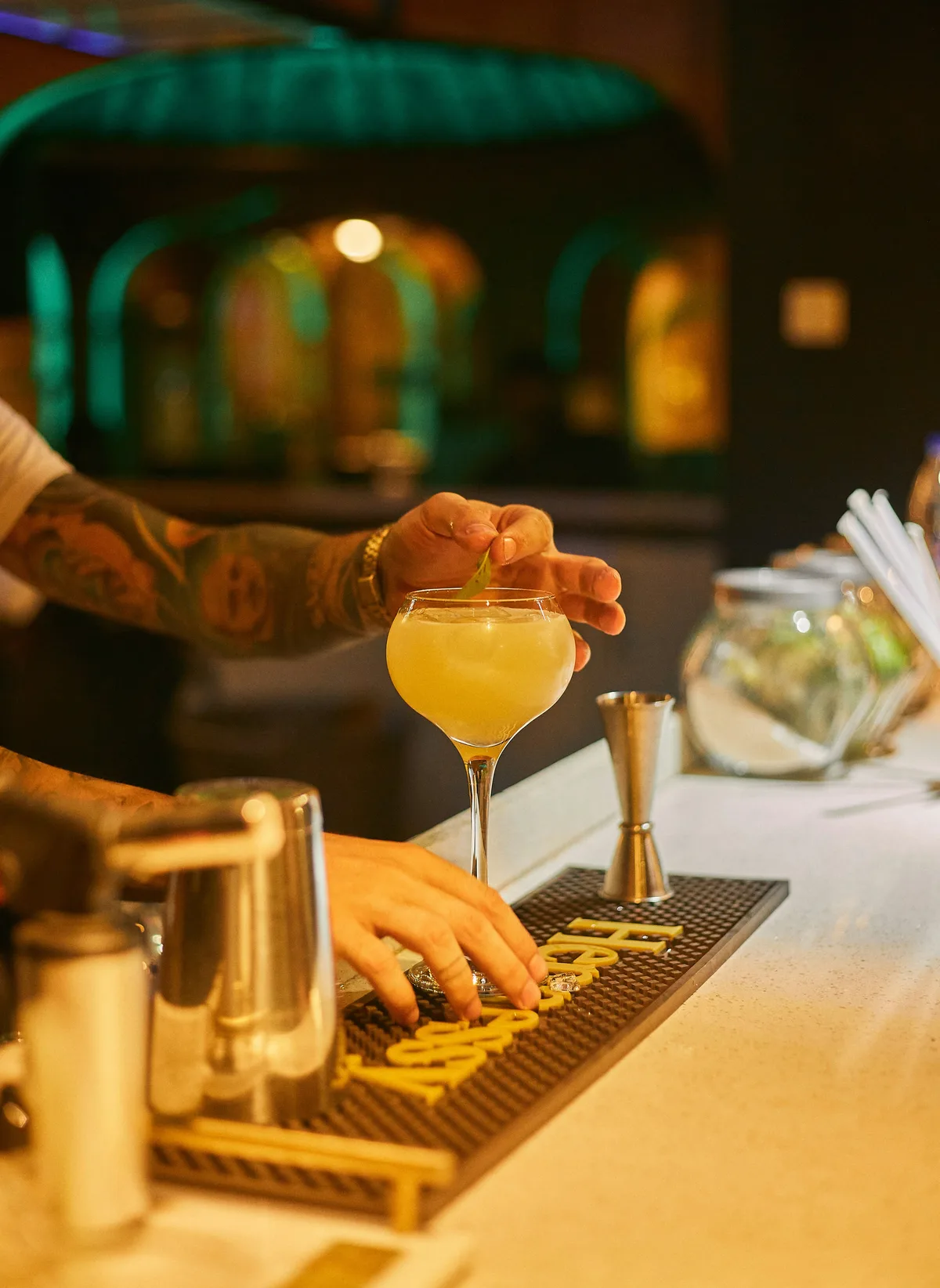 A craft cocktail being garnished with a lime wedge
