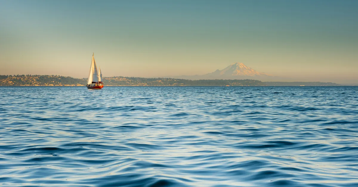 A sailboat on Puget Sound with a mountain in the distance