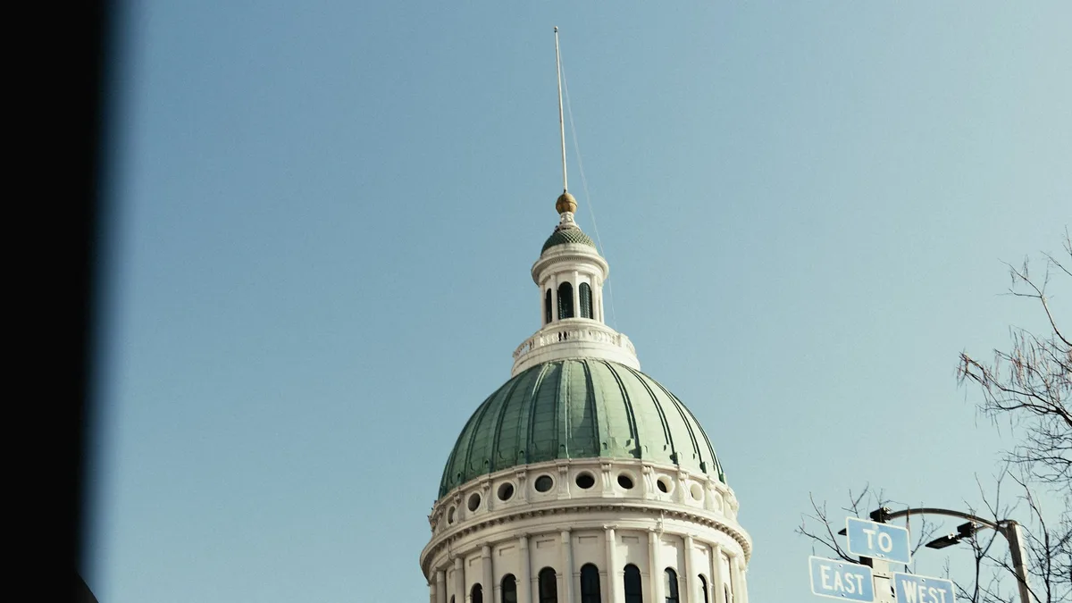 A grand stone courthouse building with a domed roof