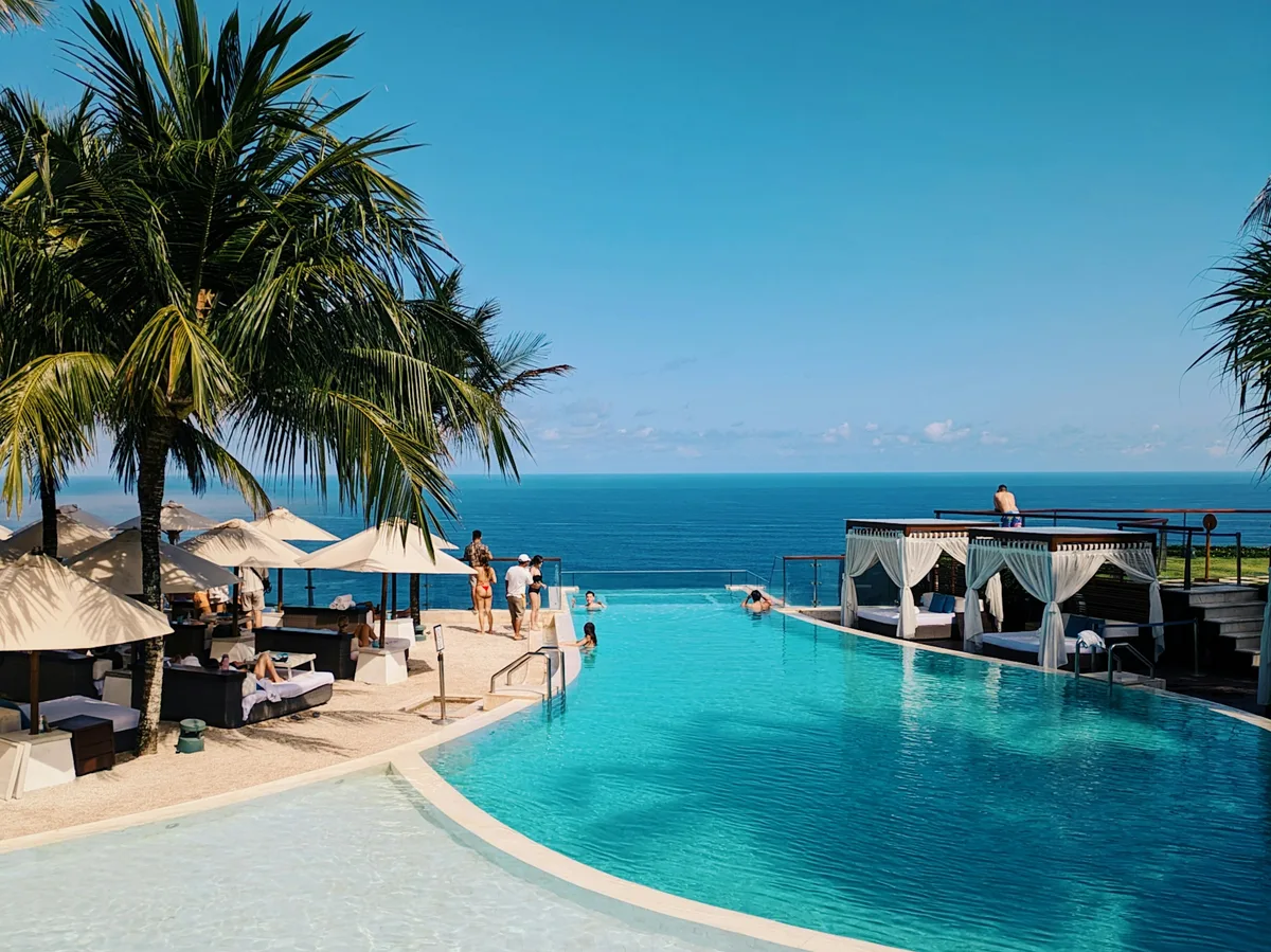 An infinity pool fringed by palm trees at a private villa resort in Bali