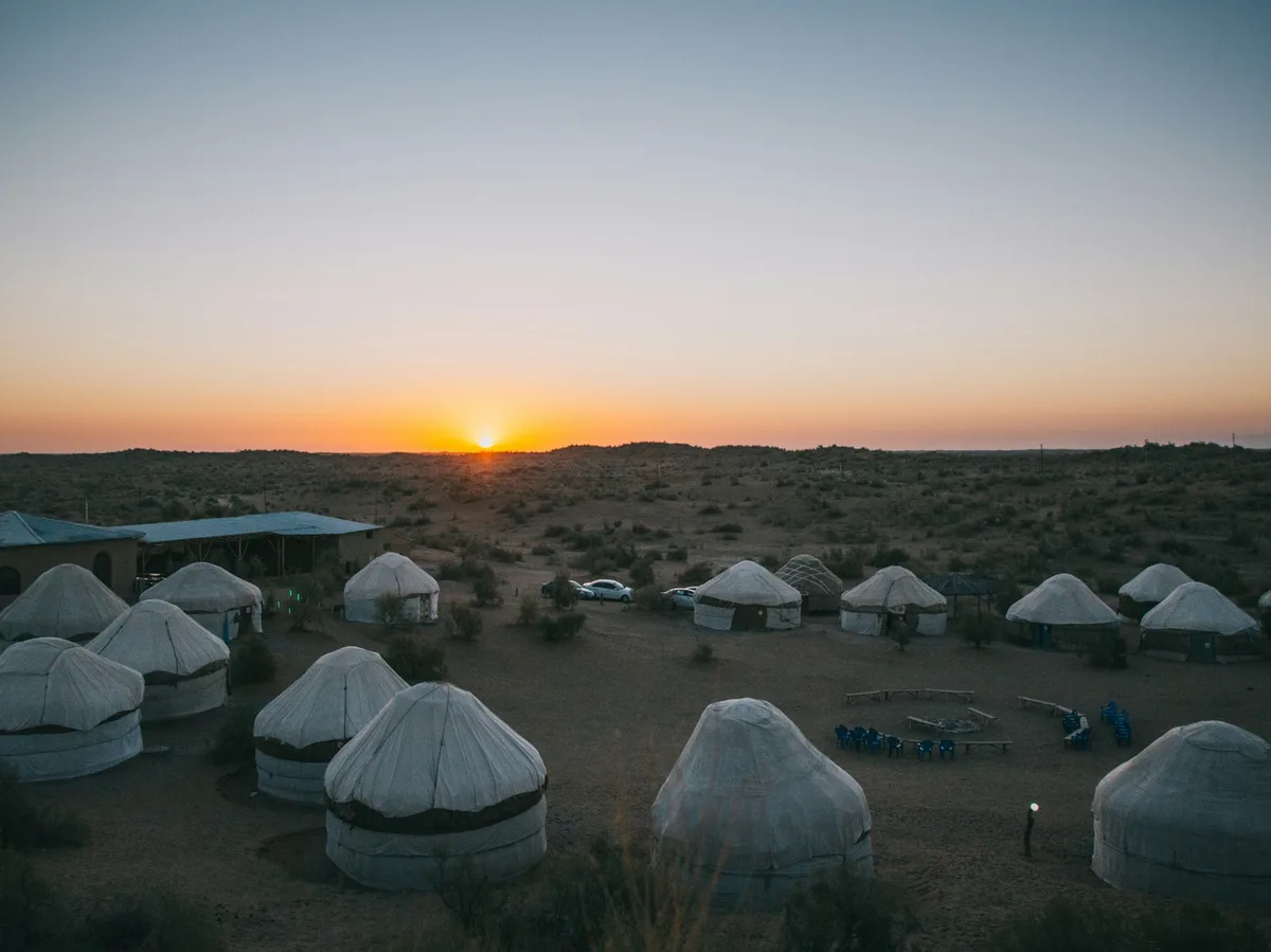 A yurt camp at sunset on the shores of Aydar Lake in the Kyzylkum Desert, Uzbekistan