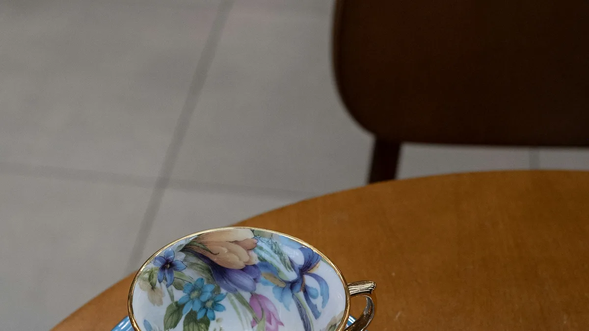 A fine bone-china teacup and saucer with a delicate floral pattern, set for tea