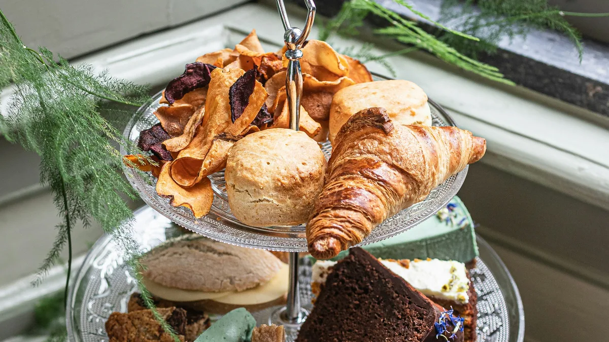 A three-tiered tray of scones, croissants, and cakes for afternoon tea