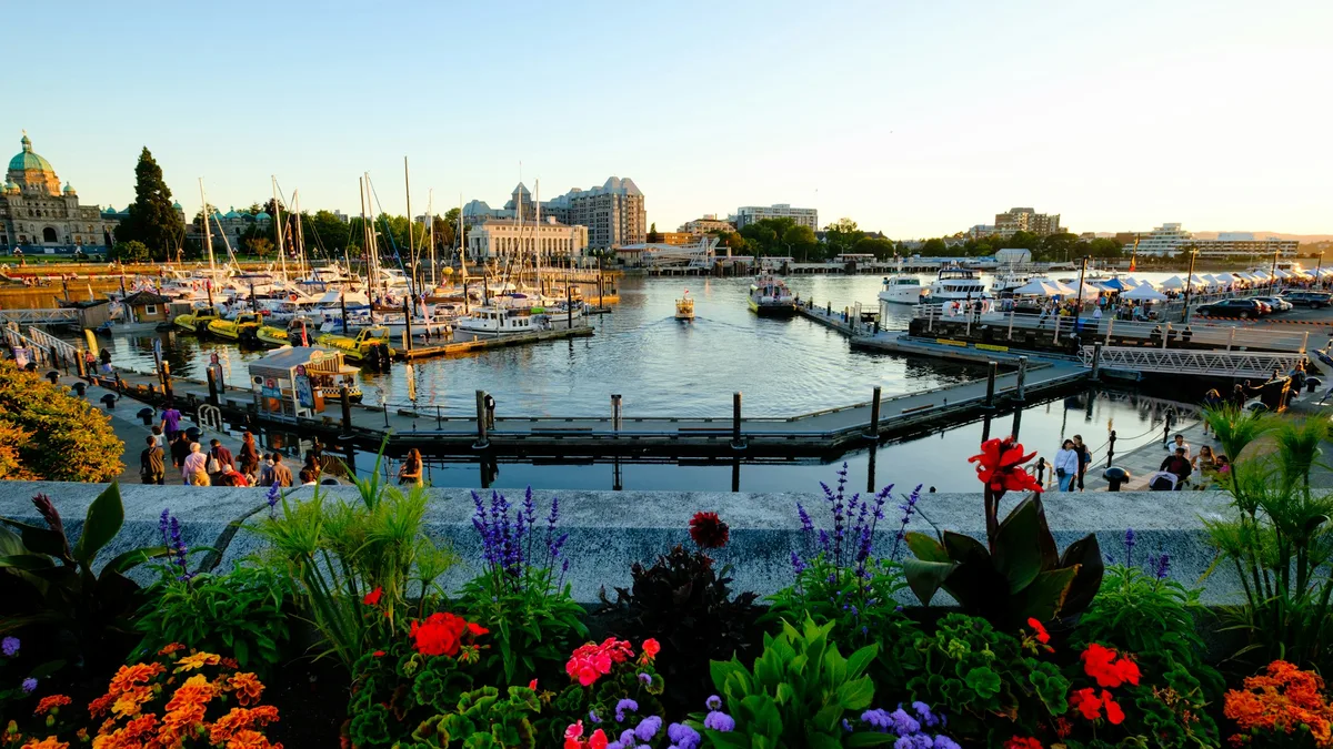 Victoria's flower-lined Inner Harbour waterfront near the cruise terminal, with the Parliament Buildings and marina in view