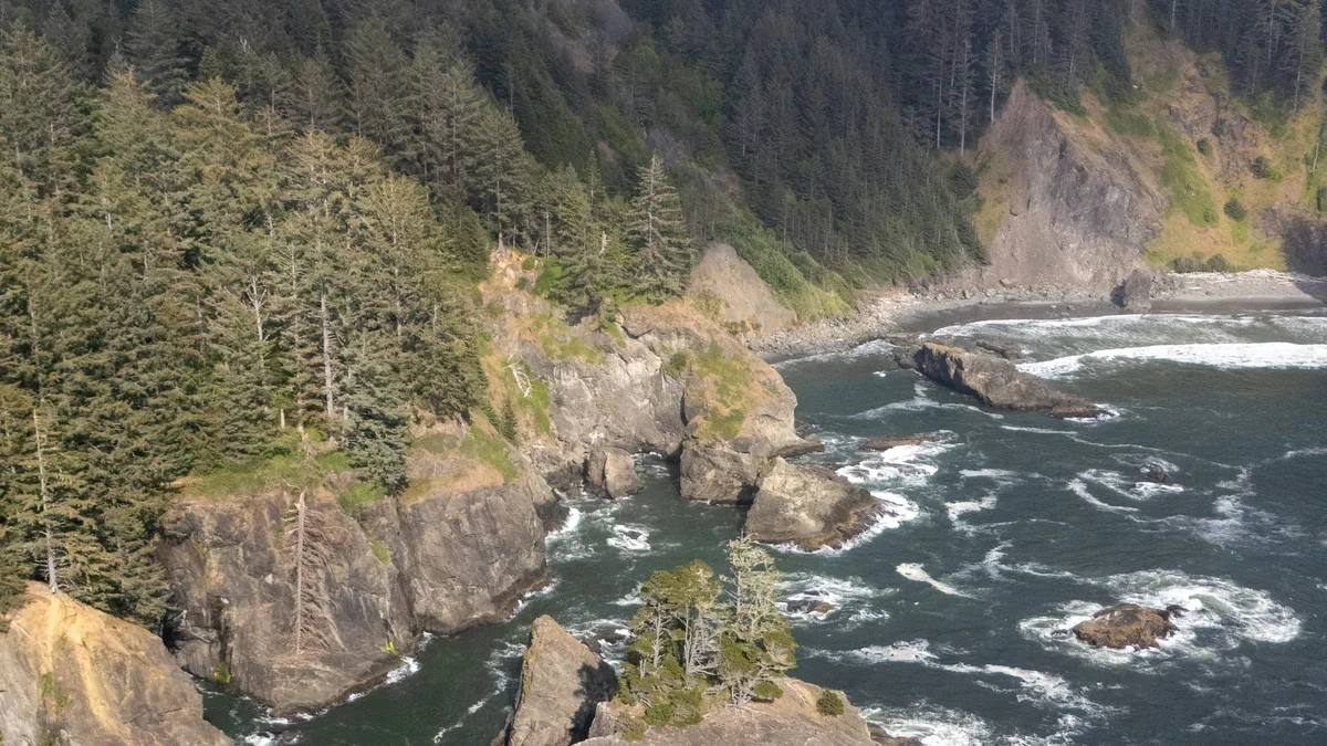 A rugged Pacific coastline with waves crashing on rocky shore