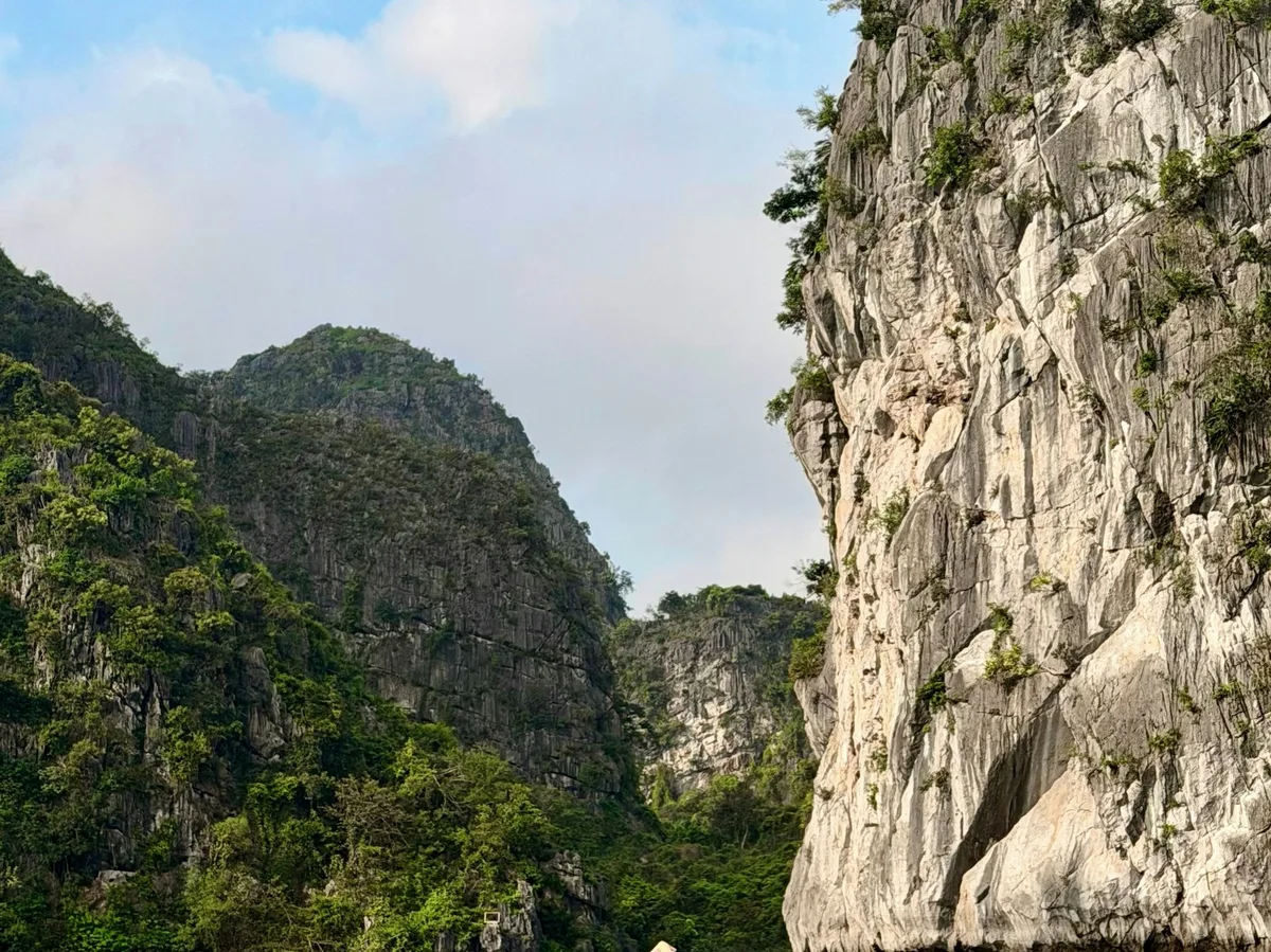 Boats gliding between limestone cliffs near Ninh Binh, Vietnam